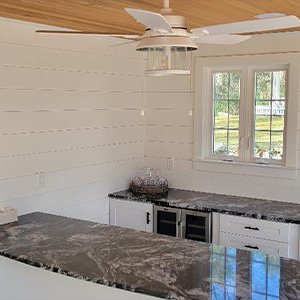 Custom kitchen with white shiplap walls and black marble countertops